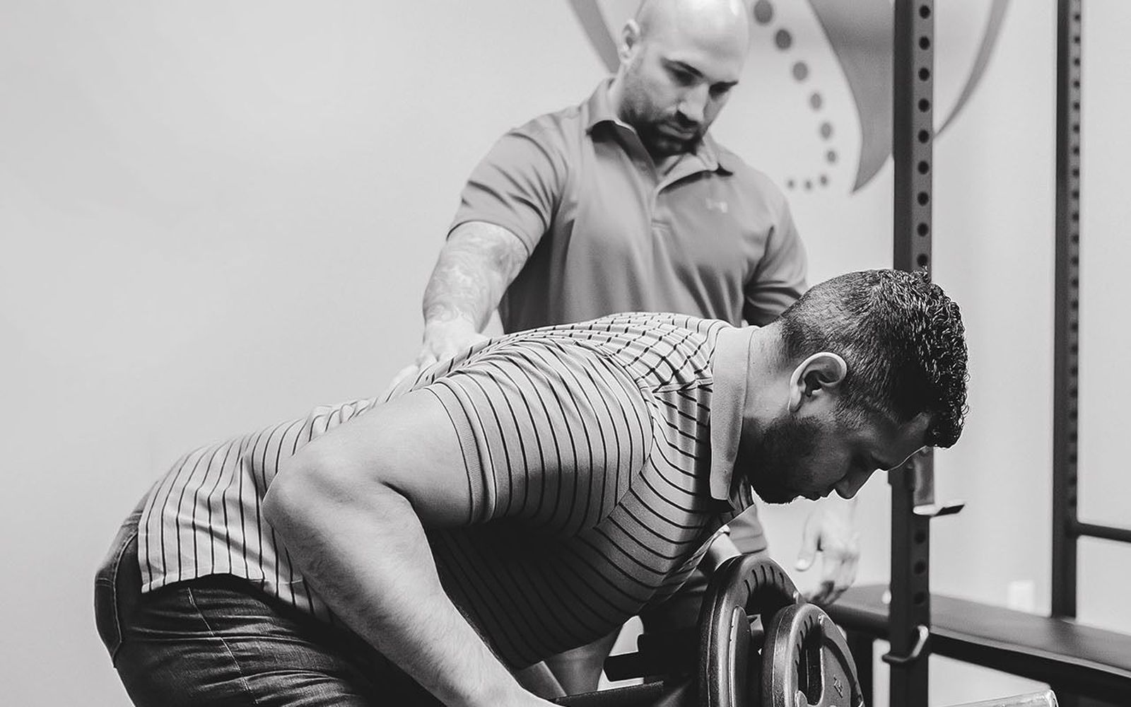 Chiropractor coaching a patient through rehab exercises in the ProActive Chiropractic and Wellness gym